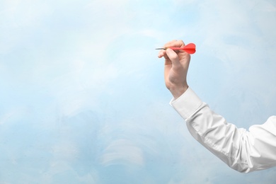 Photo of Man holding dart on color background. Business trainer concept