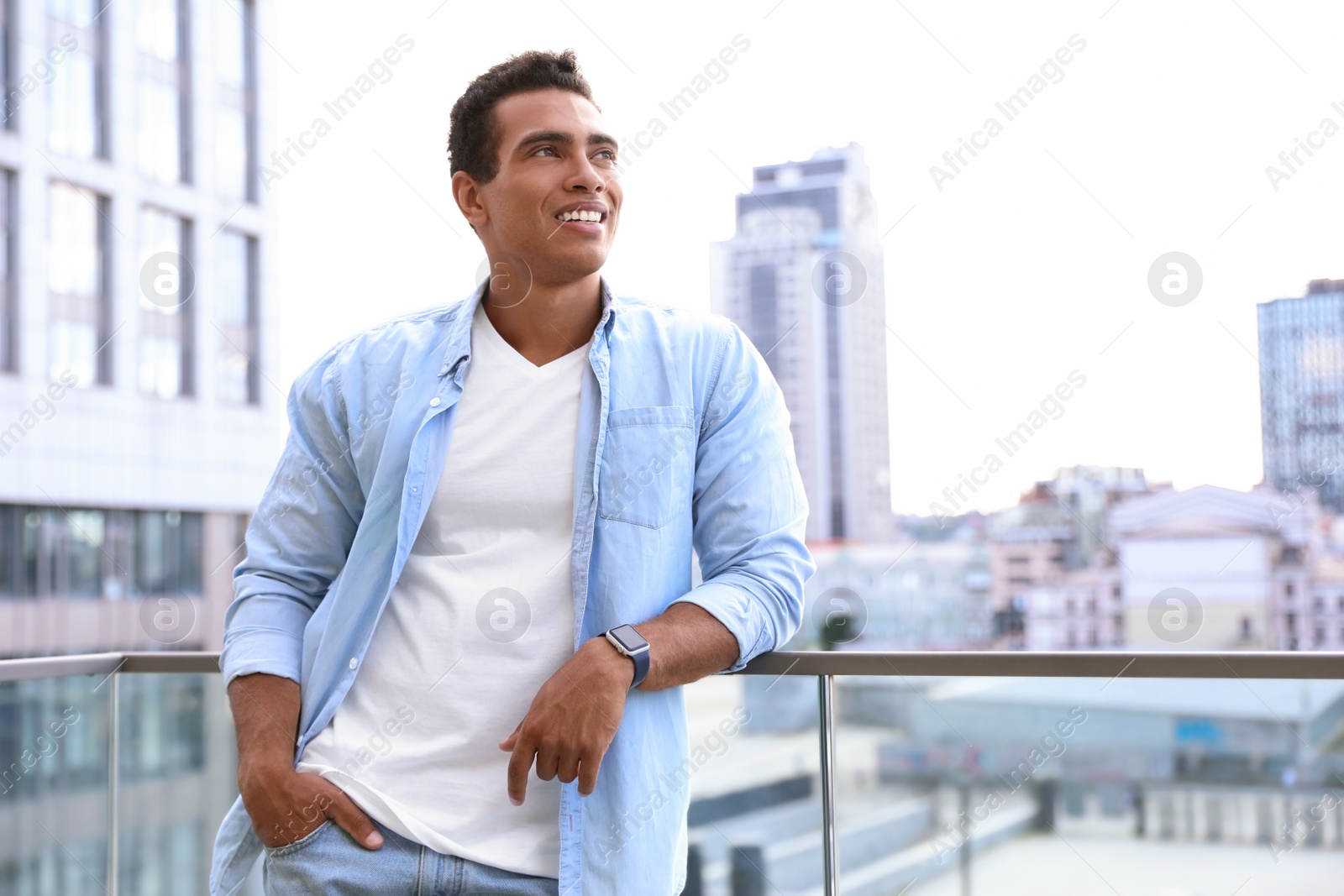 Photo of Handsome young African-American man on city street. Space for text