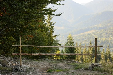Photo of Country road with wooden fence near forest in mountains