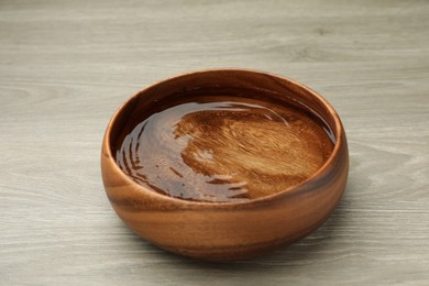 Photo of Bowl with water on wooden table, closeup