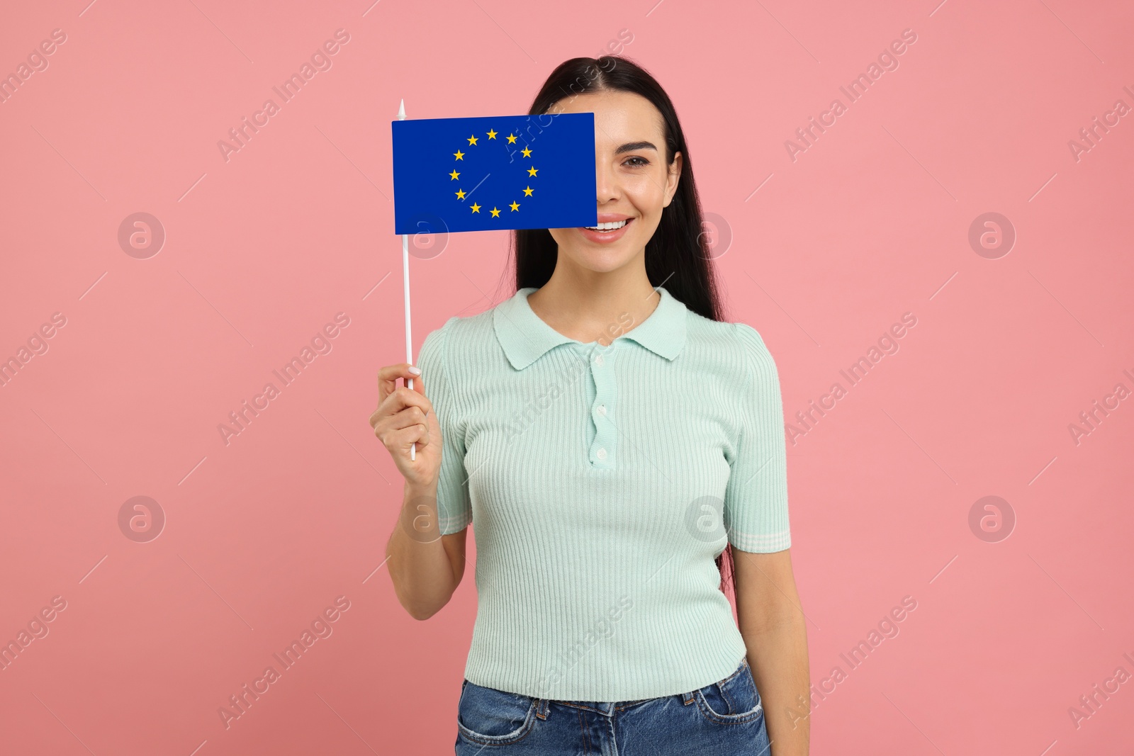 Image of Happy young woman with flag of European Union on pink background