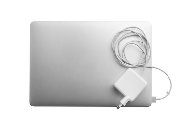 Laptop and charger on white background, top view. Modern technology