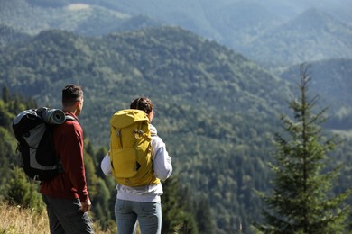 Photo of Couple with backpacks enjoying mountain landscape on sunny day