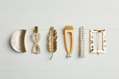 Photo of Stylish hair clips on white wooden table, flat lay