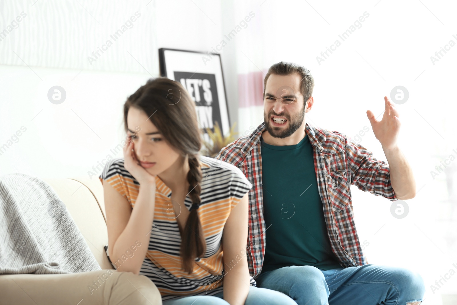 Photo of Young couple having argument in living room