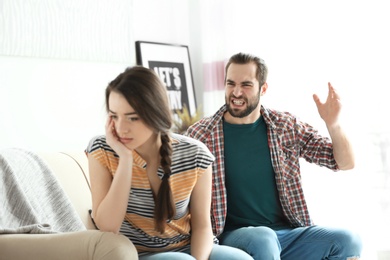 Photo of Young couple having argument in living room