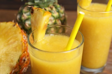 Tasty pineapple smoothie and fresh fruits on table, closeup