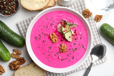Photo of Delicious cold summer beet soup on white wooden table, flat lay
