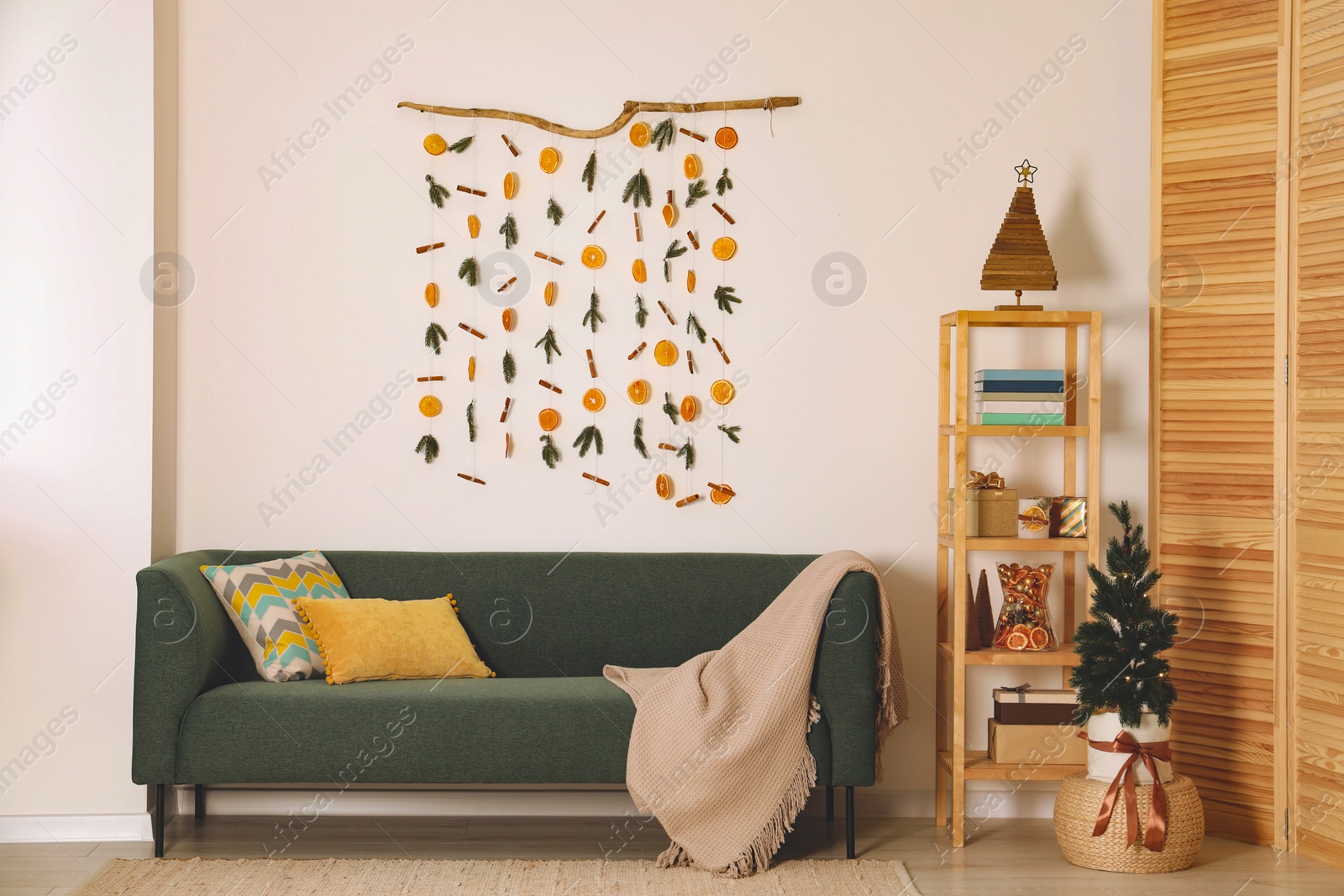 Photo of Stylish room interior with sofa and handmade dry orange decor