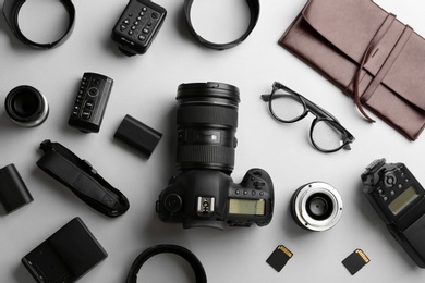Photo of Flat lay composition with professional photographer equipment on light background