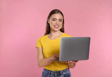 Photo of Happy woman with laptop on pink background