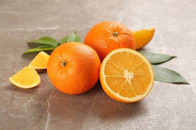 Delicious ripe oranges on grey marble table