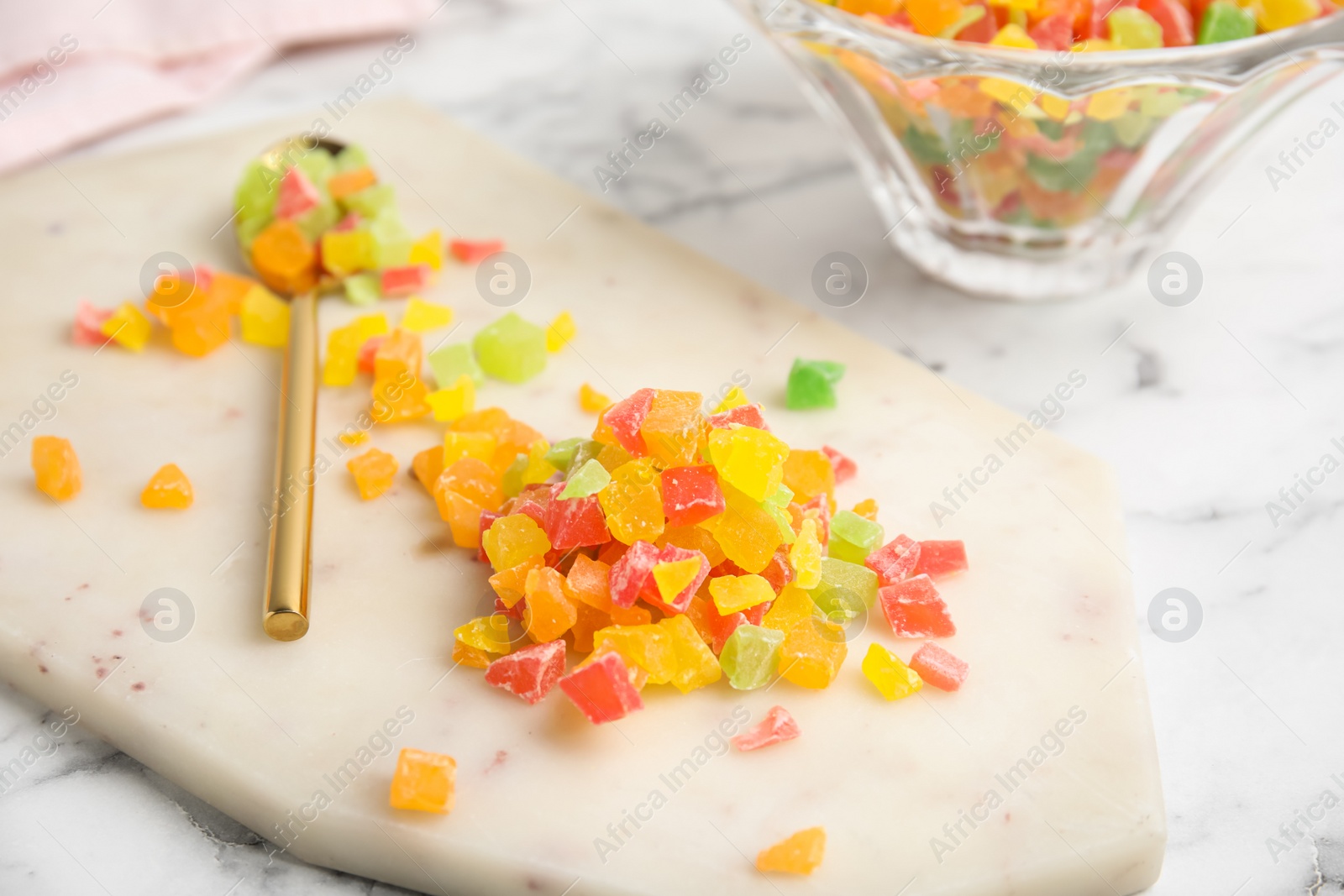 Photo of Mix of delicious candied fruits on white board, closeup