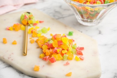 Photo of Mix of delicious candied fruits on white board, closeup