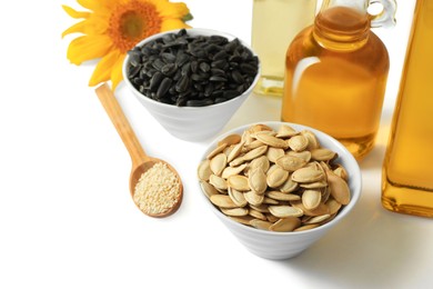 Photo of Bottles of different cooking oils, sunflower and seeds on white background