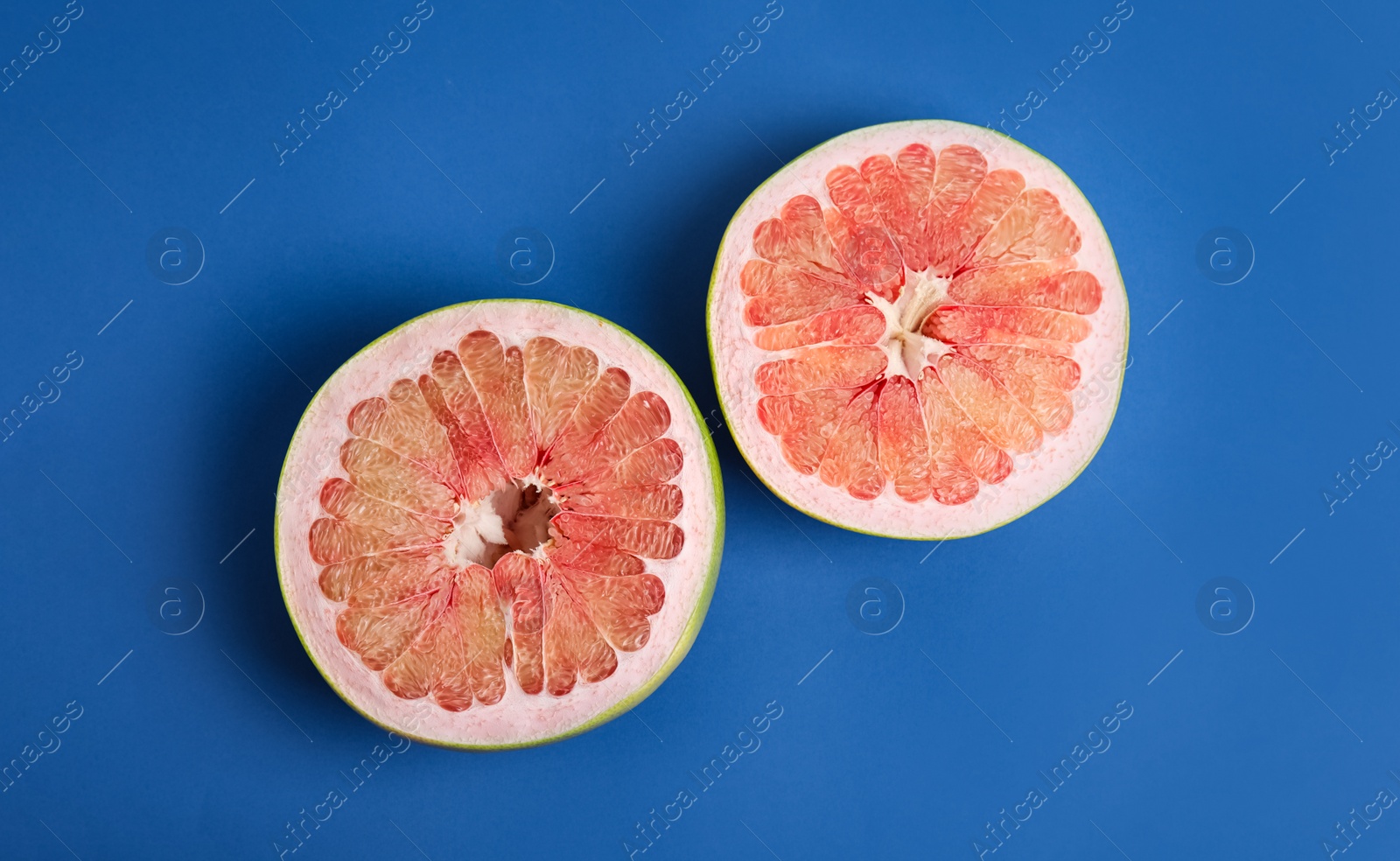 Photo of Fresh cut pomelo fruit on blue background, flat lay