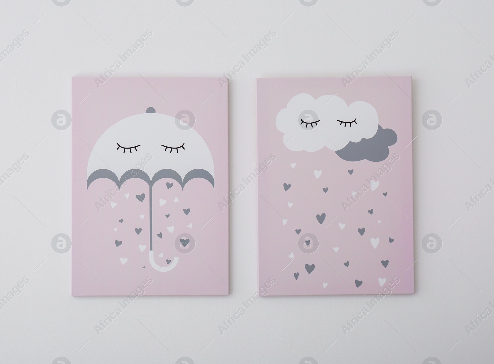 Photo of Adorable pictures of umbrella, cloud and hearts on white wall. Children's room interior elements