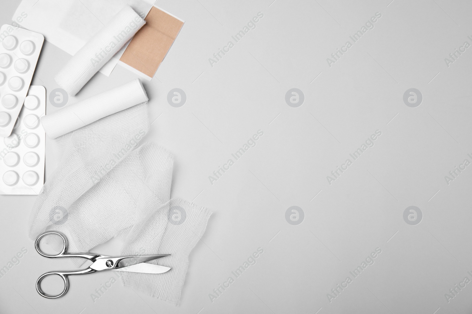 Photo of Bandage rolls and medical supplies on white background, flat lay. Space for text