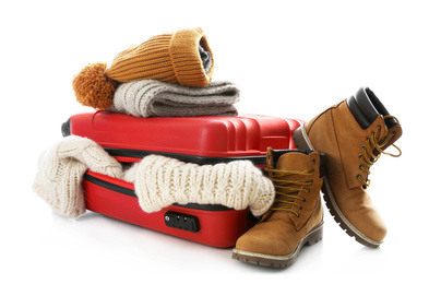 Suitcase with warm clothes isolated on white. Winter vacation