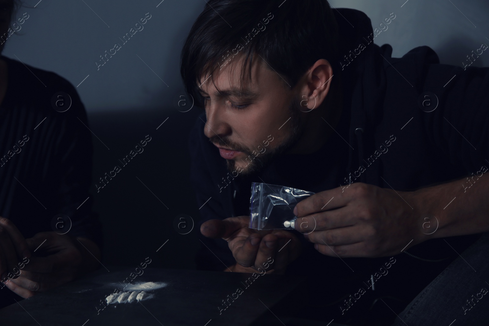 Photo of Young addicted men taking drugs on grey background