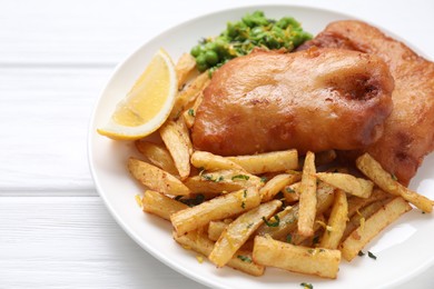 Photo of Tasty fish, chips, peas and lemon on white wooden table, closeup