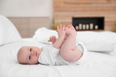 Photo of Cute little baby lying on bed at home