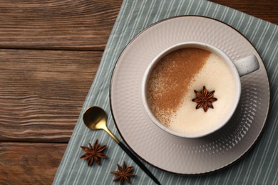 Photo of Cup of delicious eggnog with anise on wooden table, top view. Space for tex