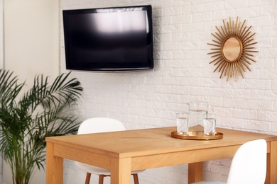 Wooden dining table in modern room interior