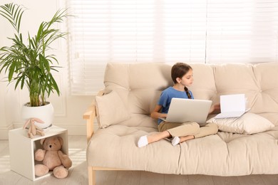 Photo of Girl with laptop and book on sofa at home