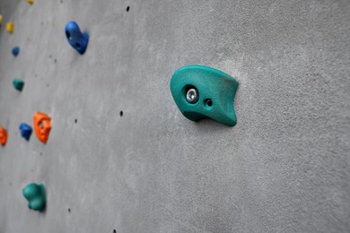 Photo of Colorful climbing wall with holds. Extreme sport