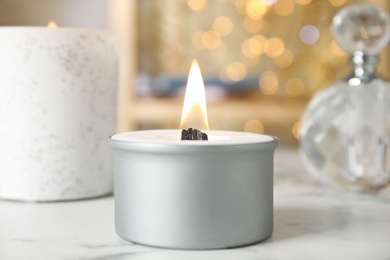 Photo of Burning candle with wooden wick on white table