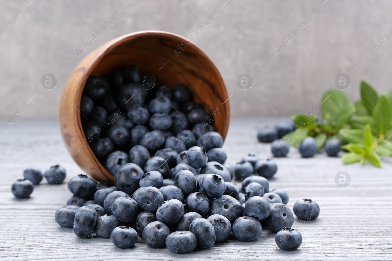 Photo of Tasty fresh blueberries on wooden table, closeup