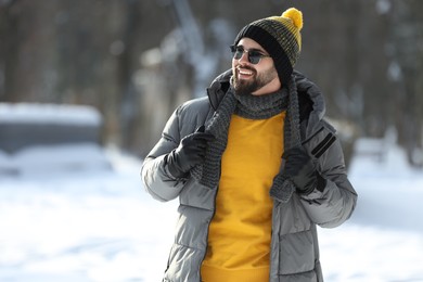 Photo of Portrait of handsome young man with sunglasses on winter day outdoors