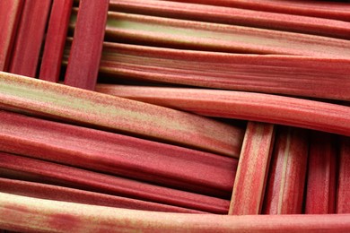 Photo of Fresh ripe rhubarb stalks as background, closeup
