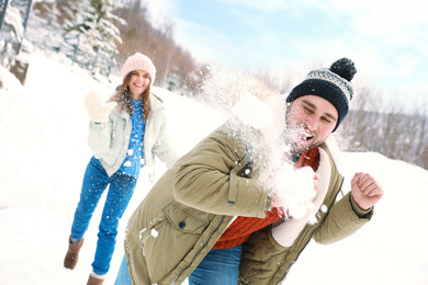 Photo of Happy couple playing snowballs outdoors. Winter vacation