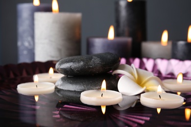Photo of Spa composition with burning candles and water in plate