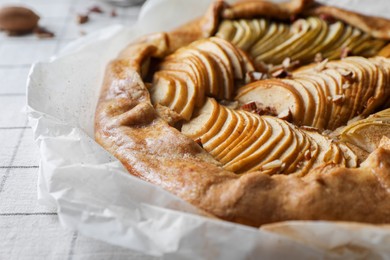 Photo of Delicious apple galette with pecans on table, closeup