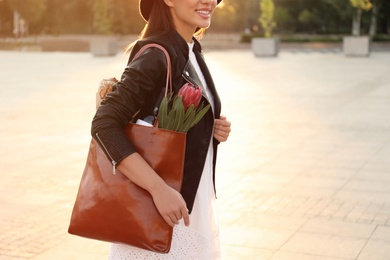 Photo of Woman with leather shopper bag on city street, closeup