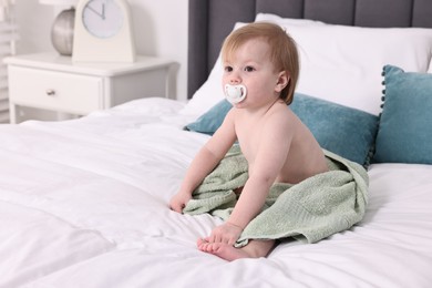 Photo of Cute little baby with towel after bathing on bed, space for text