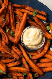 Photo of Delicious sweet potato fries served with sauce, closeup