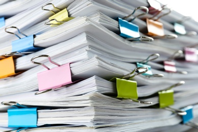 Photo of Stack of documents with binder clips as background, closeup view