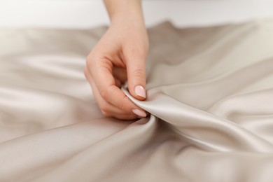 Photo of Woman touching smooth silky fabric, closeup view