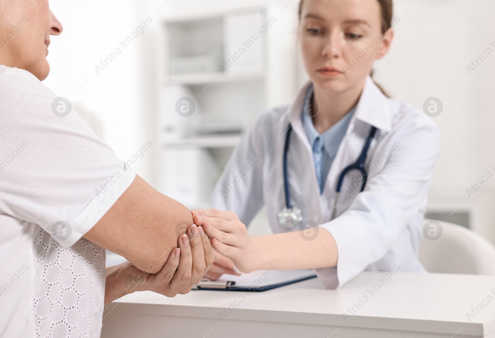 Photo of Arthritis symptoms. Doctor examining patient's elbow in hospital