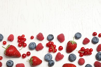 Photo of Mix of fresh berries on white wooden table, flat lay. Space for text