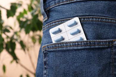 Photo of Jeans with pills in pocket, closeup. Potency problem
