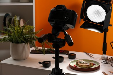 Photo of Professional equipment and composition with delicious meat medallion on white table in studio. Food photography