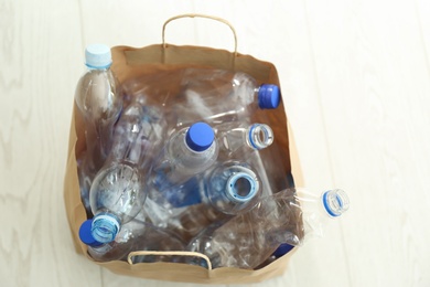 Paper bag with used plastic bottles on floor. Recycle concept
