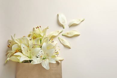 Photo of Flat lay composition with lily flowers on light background