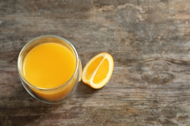 Photo of Glass of orange juice on wooden table