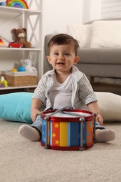 Photo of Cute little boy with toy drum at home